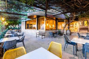 an outdoor patio with tables and chairs at Hotel Beit Maimon in Zikhron Ya'akov