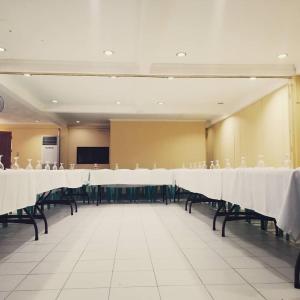 a large room with tables and chairs with white table cloth at The Waterfront Beach Resort in Morong +79 photos