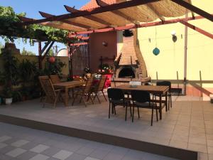eine Terrasse mit Tischen und Stühlen und einem Kamin in der Unterkunft Villa Cristina in Mangalia