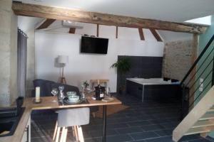 a living room with a table and a bath tub at Maison privative, cocooning, zen , avec jacuzzi in Mont-Notre-Dame