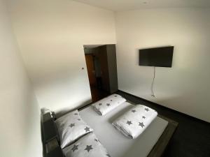 a bedroom with a bed with two pillows and a flat screen tv at Moto-Center BeO AG (Bike & Bed) in Brienz