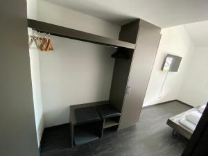 um quarto com um banco preto num quarto em Moto-Center BeO AG (Bike & Bed) em Brienz