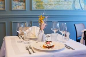 a table with a plate of food and wine glasses at Heritage Hotel Porin Makarska in Makarska