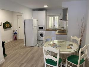 uma cozinha com uma mesa de vidro e electrodomésticos brancos em Apartamento Dacosta em Plasencia
