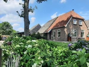 a house with a garden of flowers in front of it at Bed en Breakfast Gees in Gees