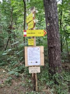 a sign in the middle of a forest at Rifugio Casa Ressia in Sassello