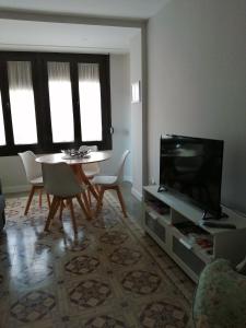un soggiorno con TV, tavolo e sedie di Casa de la abuela pequeña a Teruel