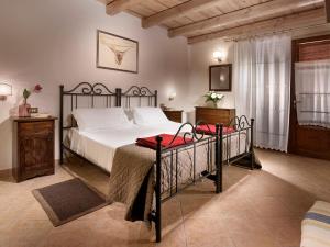 サン・ジョヴァンニ・ヴァルダルノにあるAgriturismo Valleverdeのベッドルーム1室(黒枠の大型ベッド1台付)