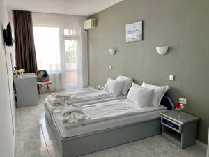 A bed or beds in a room at Plovdiv Hotel