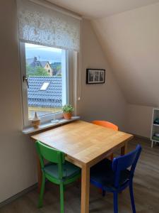 a dining room table with two chairs and a window at Gästehaus VillaVerde in Kelberg