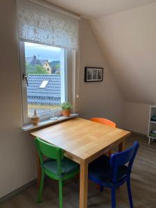 einem Esstisch mit 2 Stühlen und einem Fenster in der Unterkunft Gästehaus VillaVerde in Kelberg