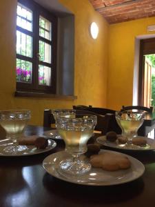 una mesa con tres copas de vino y galletas en ella en Rifugio Casa Ressia en Sassello