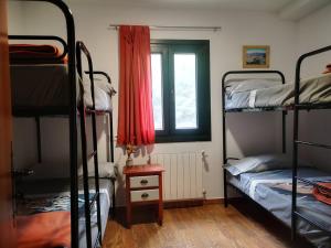 Un dormitorio con dos literas y una ventana. en La Rejertilla, en El Burgo