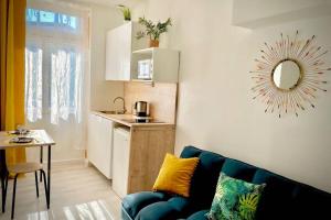 Il comprend un salon avec un canapé bleu et une cuisine. dans l'établissement STUDIO VAISE 3 CENTRE à LYON 69009, à Lyon