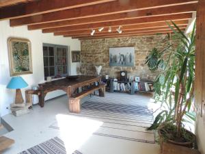 a living room with a wooden table and a stone wall at Grande maison avec extension d'architecte à 700m de la plage in Brest