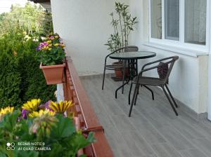 un patio con mesa, sillas y flores en Liget Fruit Garden, en Zalakaros