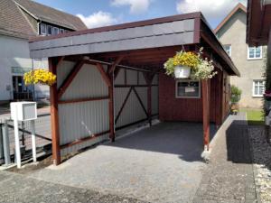 a garage with awning and flower baskets on it at Pension Stahlberg in Lübz