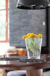 a vase of yellow flowers sitting on a table at Baltic Apartments Beach Residence in Gdańsk