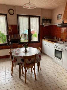 una cocina con mesa y sillas. en L hotellerie de la gare en Bruley