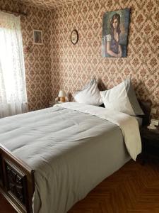 a bedroom with a large white bed in a room at L hotellerie de la gare in Bruley