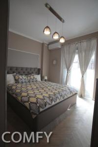 a bedroom with a bed with a comforter on it at Live Bucharest in Bucharest