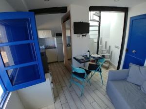 sala de estar con puerta azul, mesa y sofá en Sabbia Suites Serena Studio en Arrecife