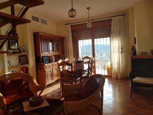 a living room with chairs and a table and a kitchen at Agradable Chalet con piscina en Villaharta in Villaharta