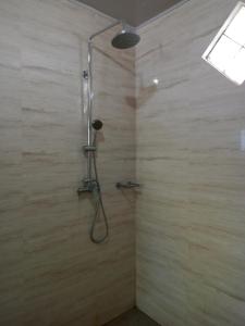 a shower with a shower head in a bathroom at Yohanes Guest House Sorake Surf-Nias in Lagudri