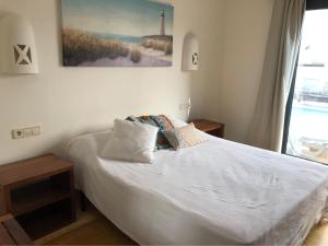 sypialnia z białym łóżkiem i oknem w obiekcie Villa Lena w mieście Playa Blanca