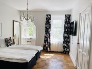a bedroom with two beds and a chandelier at aday - Aalborg Mansion - 3 bedroom apartment in Aalborg