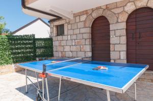 a ping pong table in front of a house at Holiday Home Mateovi Dvori in Imotski