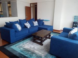 a living room with blue couches and a coffee table at Karen View Palace Apartments in Nairobi
