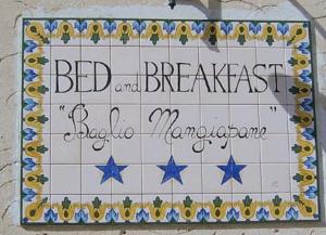 een bord voor een bed and breakfast op een tegelmuur bij B & B Baglio Mangiapane in Custonaci