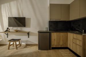 a kitchen with a black refrigerator and a tv at Casa Costa Suites in Kanali