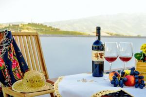 a bottle of wine sitting on a table with two glasses at Hidden Gem w/ Rooftop - City Center & Douro View in Peso da Régua