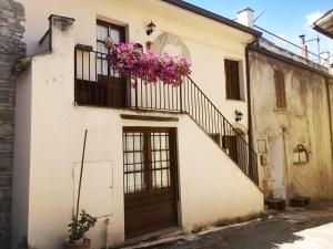 a white building with flowers on a balcony at Alloggio Turistico Gasparrini in Bevagna