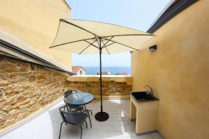 a patio with a table and an umbrella at Il Miglio in Più in Castel di Tusa