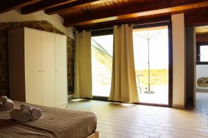 a bedroom with a bed and a large sliding glass door at Il Miglio in Più in Castel di Tusa