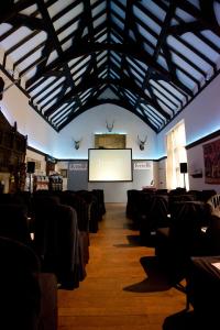 a room with chairs and a screen with a presentation at Burton Court in Dilwyn