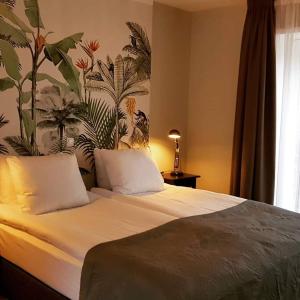 a bedroom with a bed with a floral wall at Hotel dependance Anna's zusje in Harlingen