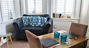 a living room with a table and a chair at A Beautiful Apartment with Stunning Sea Views & Private Balcony in Bournemouth