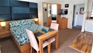 ボーンマスにあるA Beautiful Apartment with Stunning Sea Views & Private Balconyのベッドルーム1室(ベッド1台、テーブル、椅子付)
