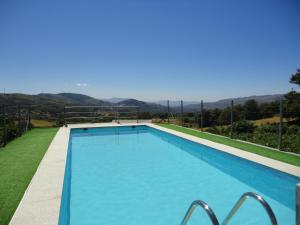 a swimming pool with a view of the mountains at O ROCHA in Paredes do Rio