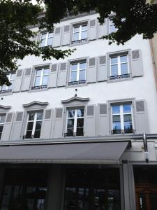 ein weißes Gebäude mit Seitenfenstern in der Unterkunft Residence Apartments by Hotel du Commerce in Basel