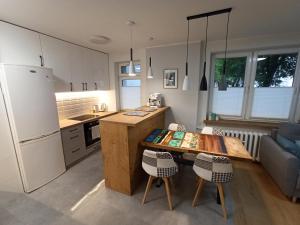 a kitchen with a table and a refrigerator at Flat White Centrum in Suwałki