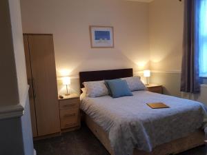 A bed or beds in a room at Marshall Lodge Guest House 