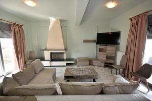 een woonkamer met een bank en een tv bij APOSTOLIAS APARTMENTS in Volos