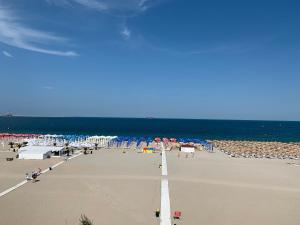 uma praia com cadeiras e guarda-sóis e o oceano em Summer apartments em Eforie Nord