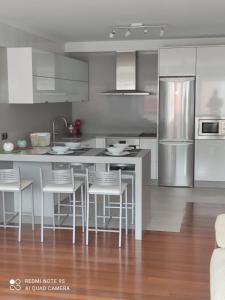 a kitchen with stainless steel appliances and a kitchen island at Apartamento Paula in Cee