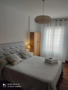 a bedroom with a large bed with a white bedspread at Apartamento Paula in Cee